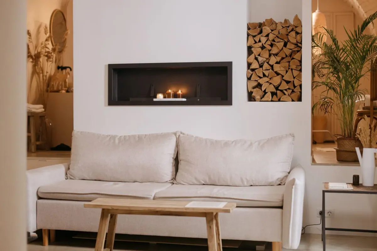Heller Wohnbereich mit cremefarbenem Sofa, Holztisch und Kamin – Wohninspiration